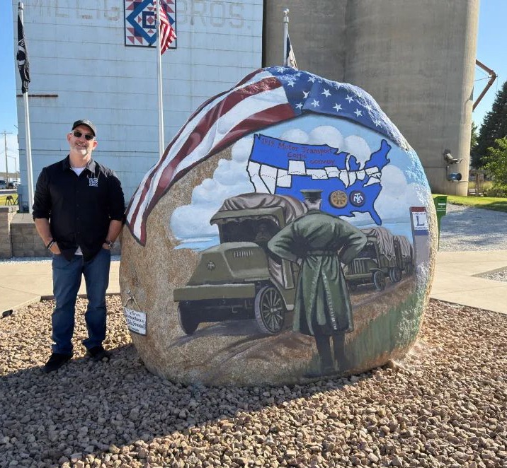 Jeremy Glazier standing beside the Greene County Freedom Rock in Jefferson, Iowa.